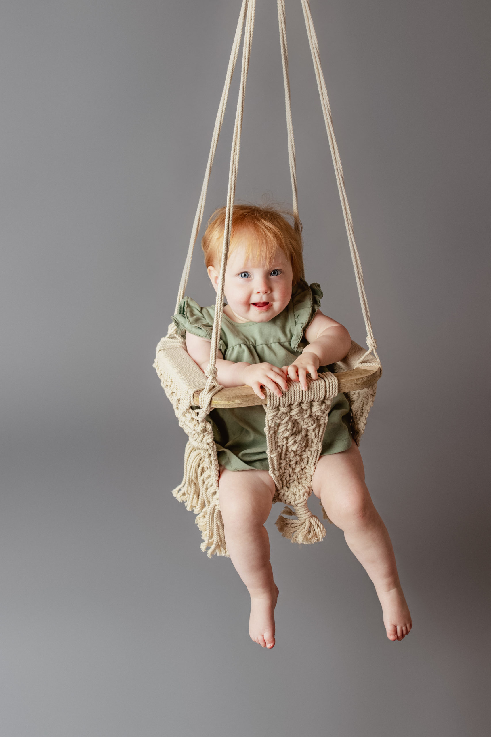Baby swinging while wearing a dress from Goo Goo Gaa Gaa in Brookfield, WI
