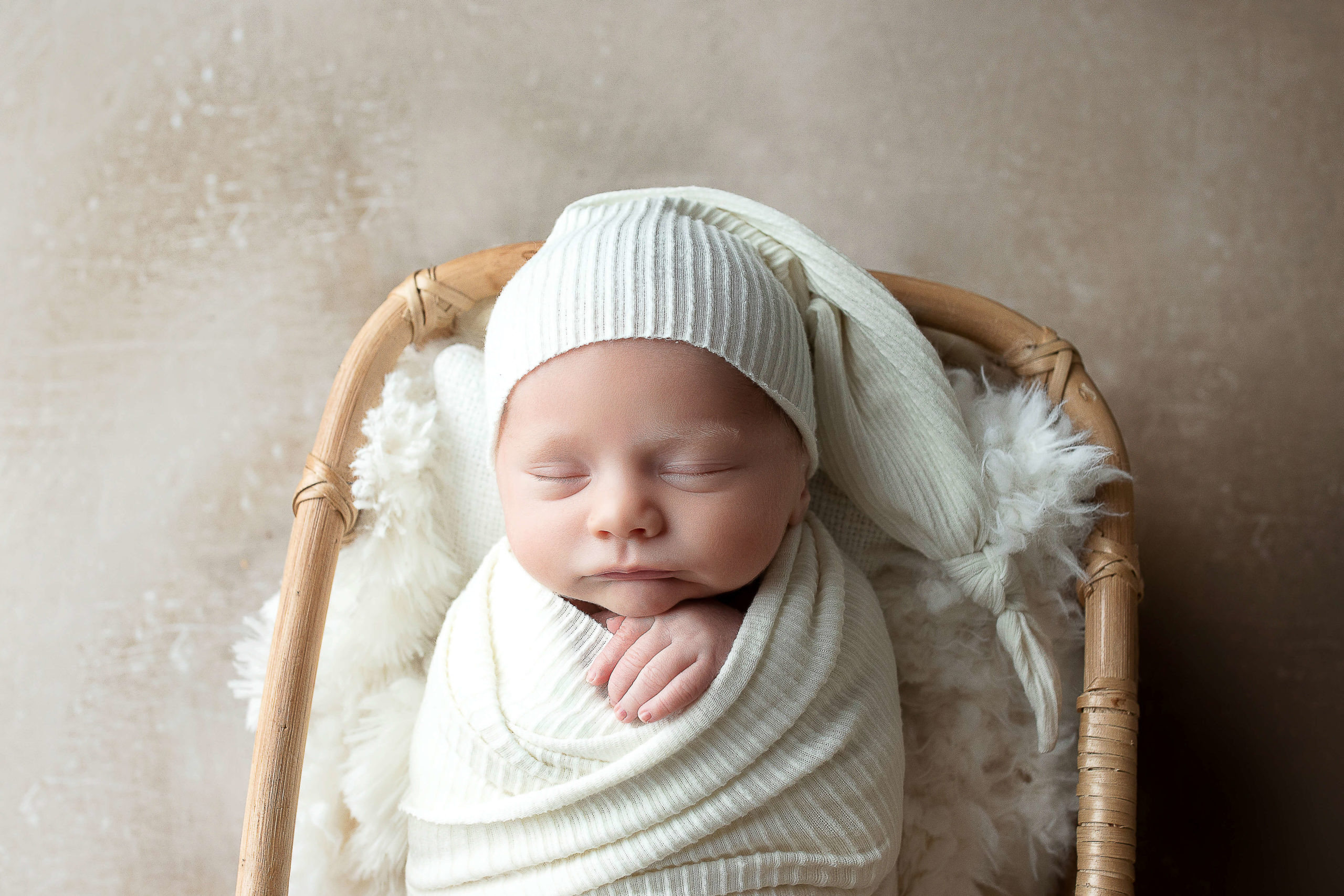 Newborn wrapped while wearing a sleepy cap