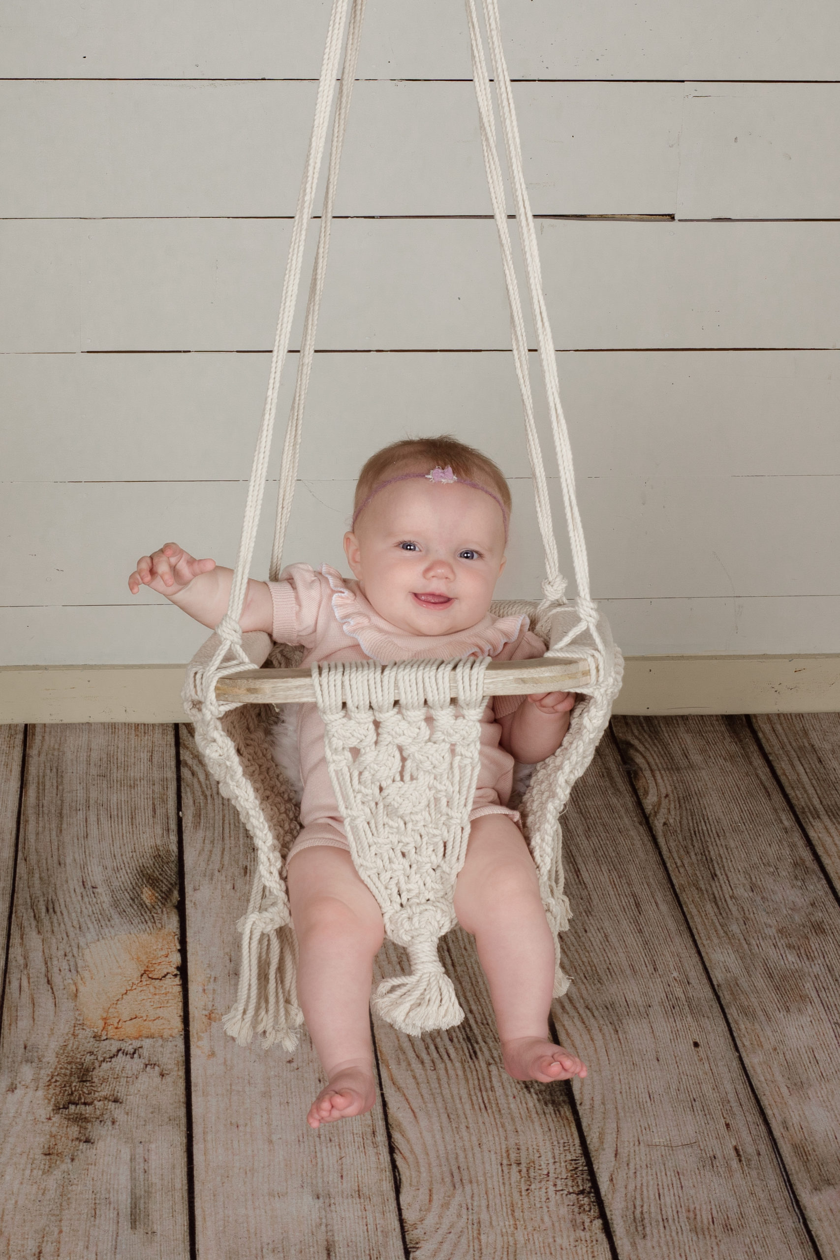 Young baby in a macrame swing for a milestone photography session