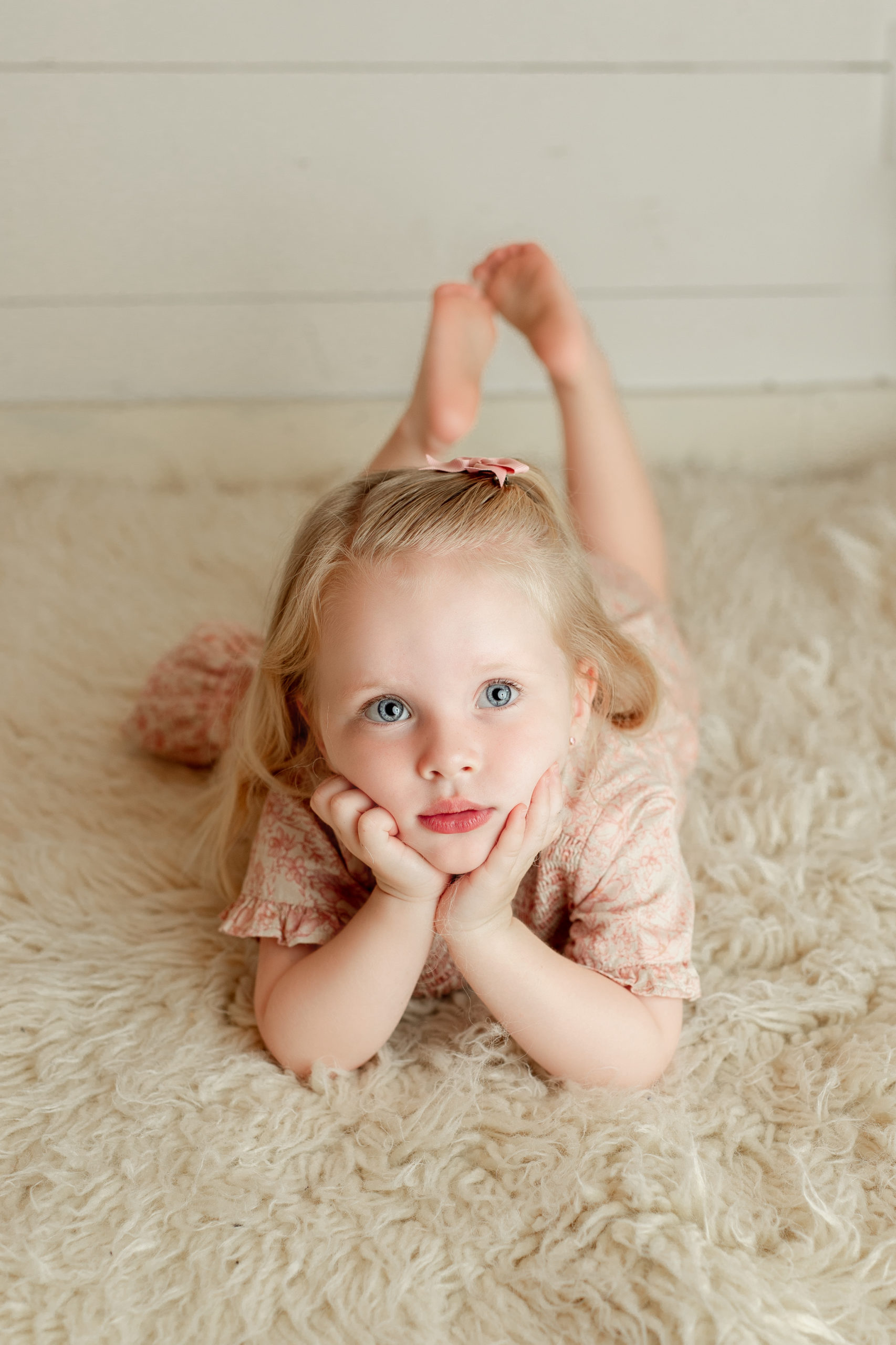 Child posing on a flokati rug with a photo done by a Milwaukee family photographer