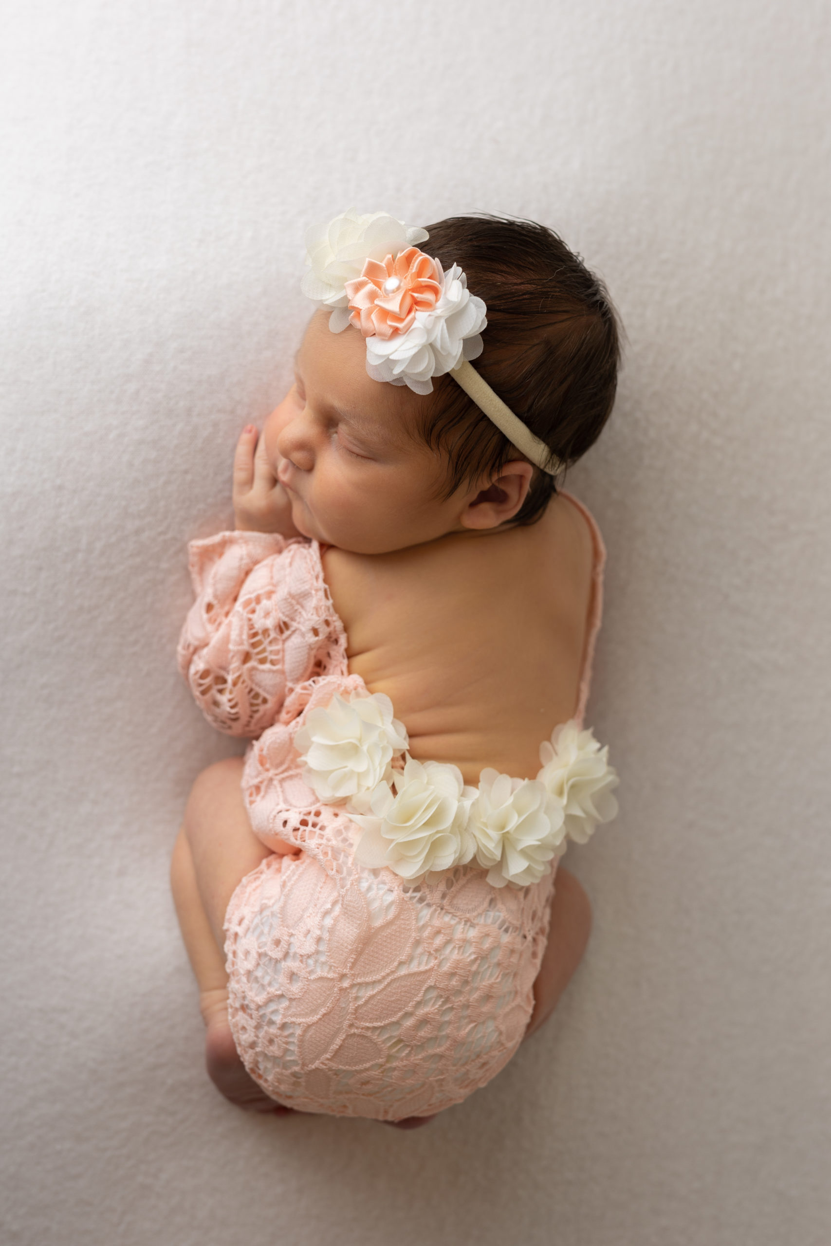 Milwaukee newborn photographer took a photo of a baby girl in a pink lace outfit