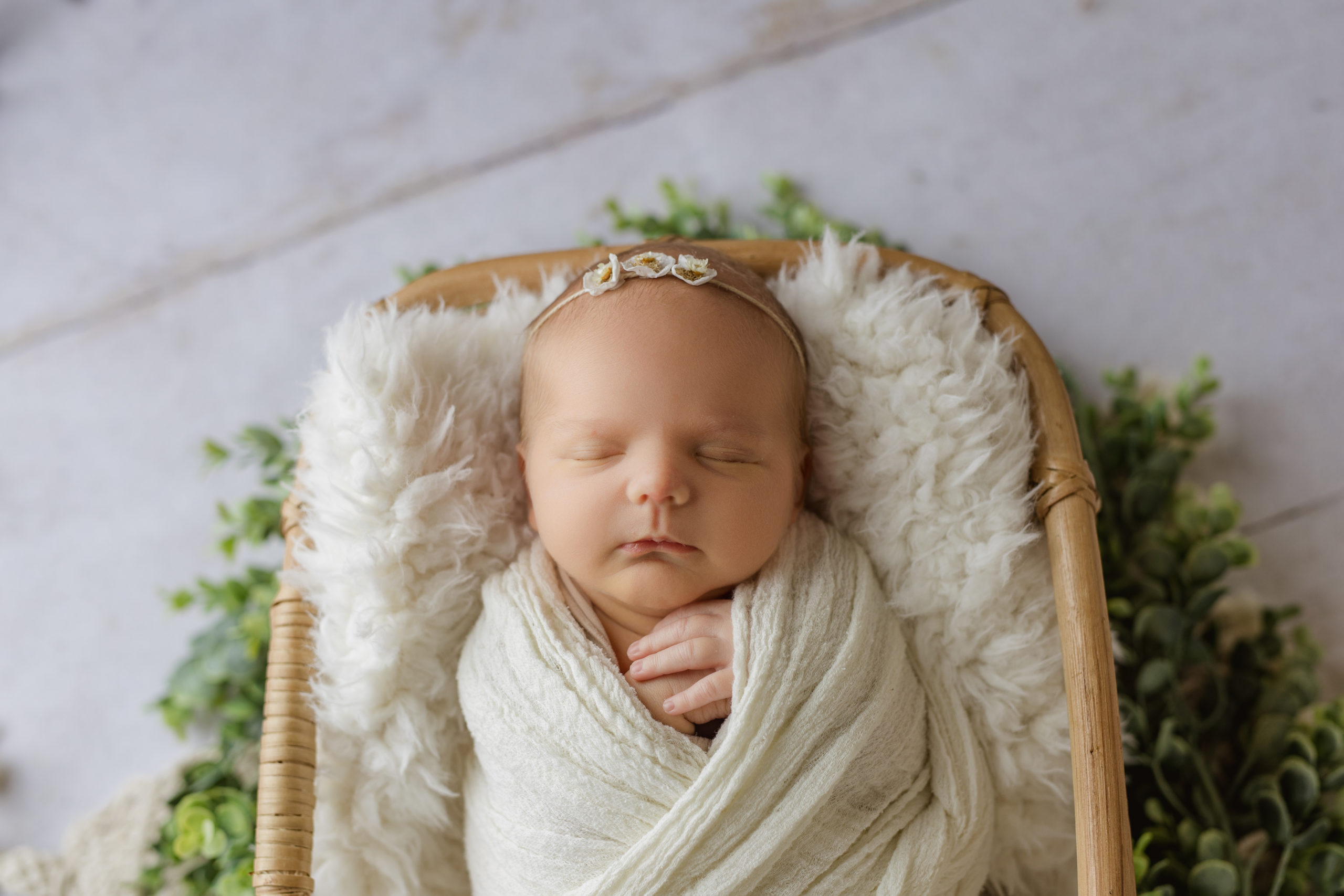 Newborn baby girl in a white wrap for newborn photos