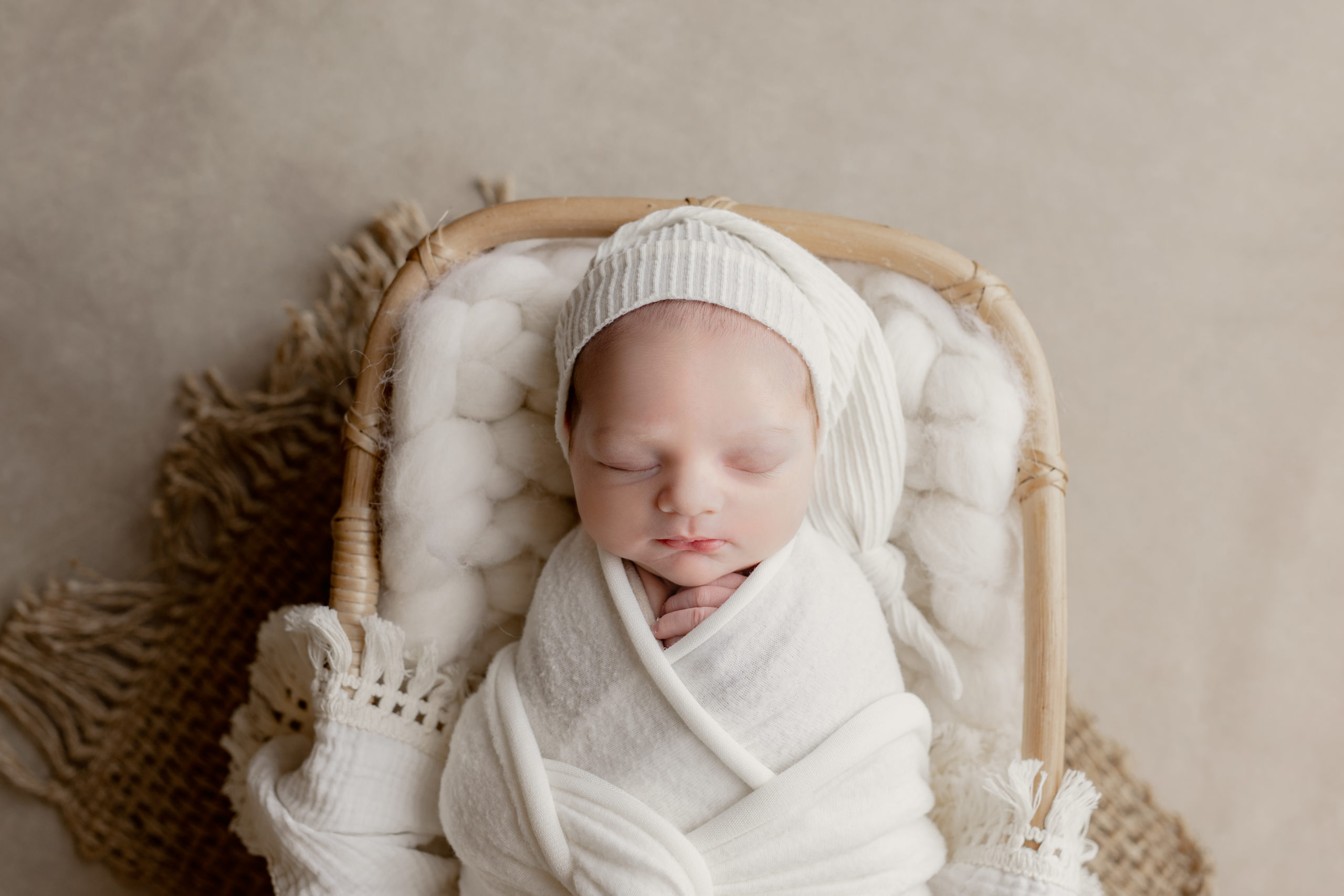 newborn boy in all cream for pictures taken by a Milwaukee newborn photographer