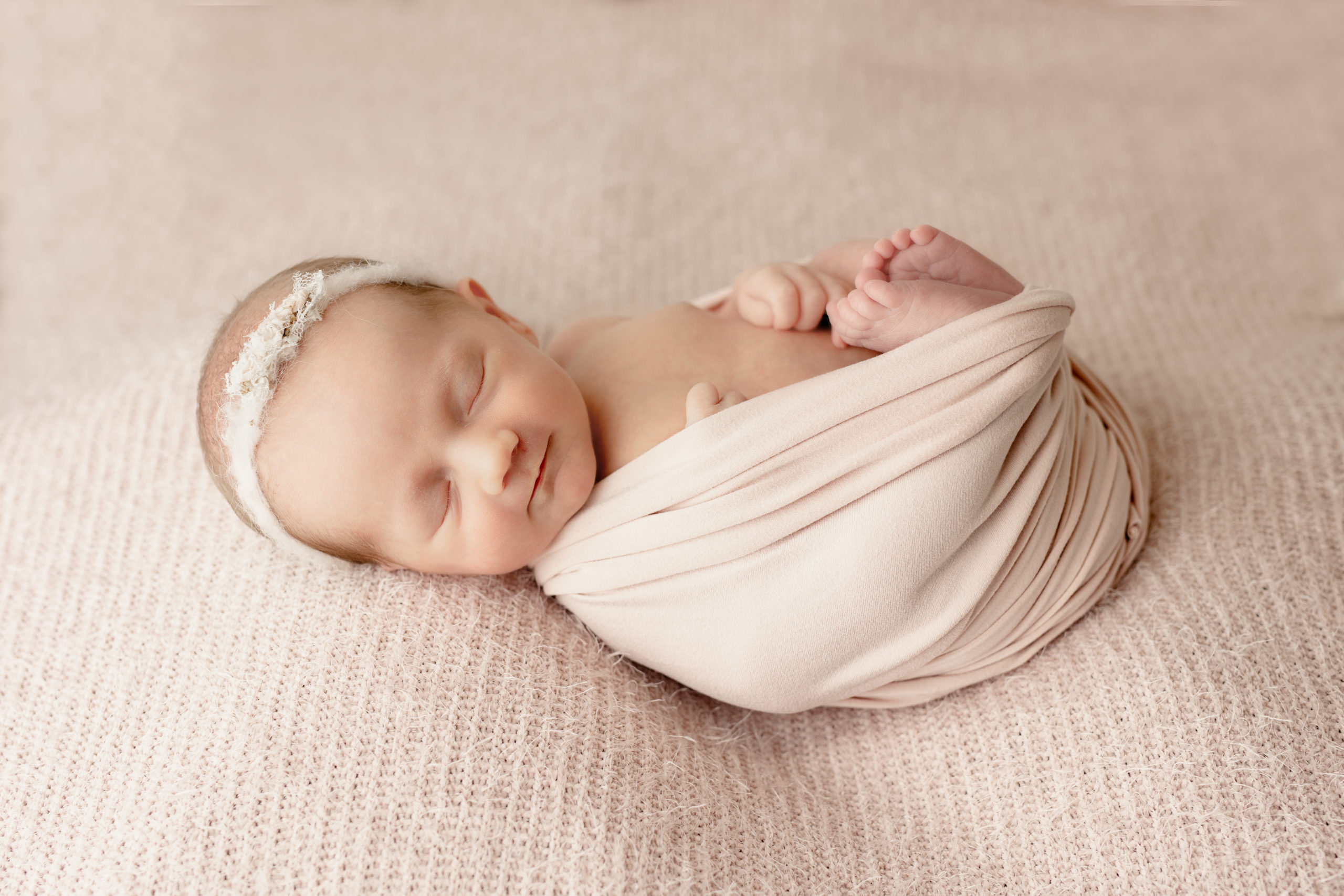 Milwaukee newborn photographer photo of newborn girl in a light pink blanket