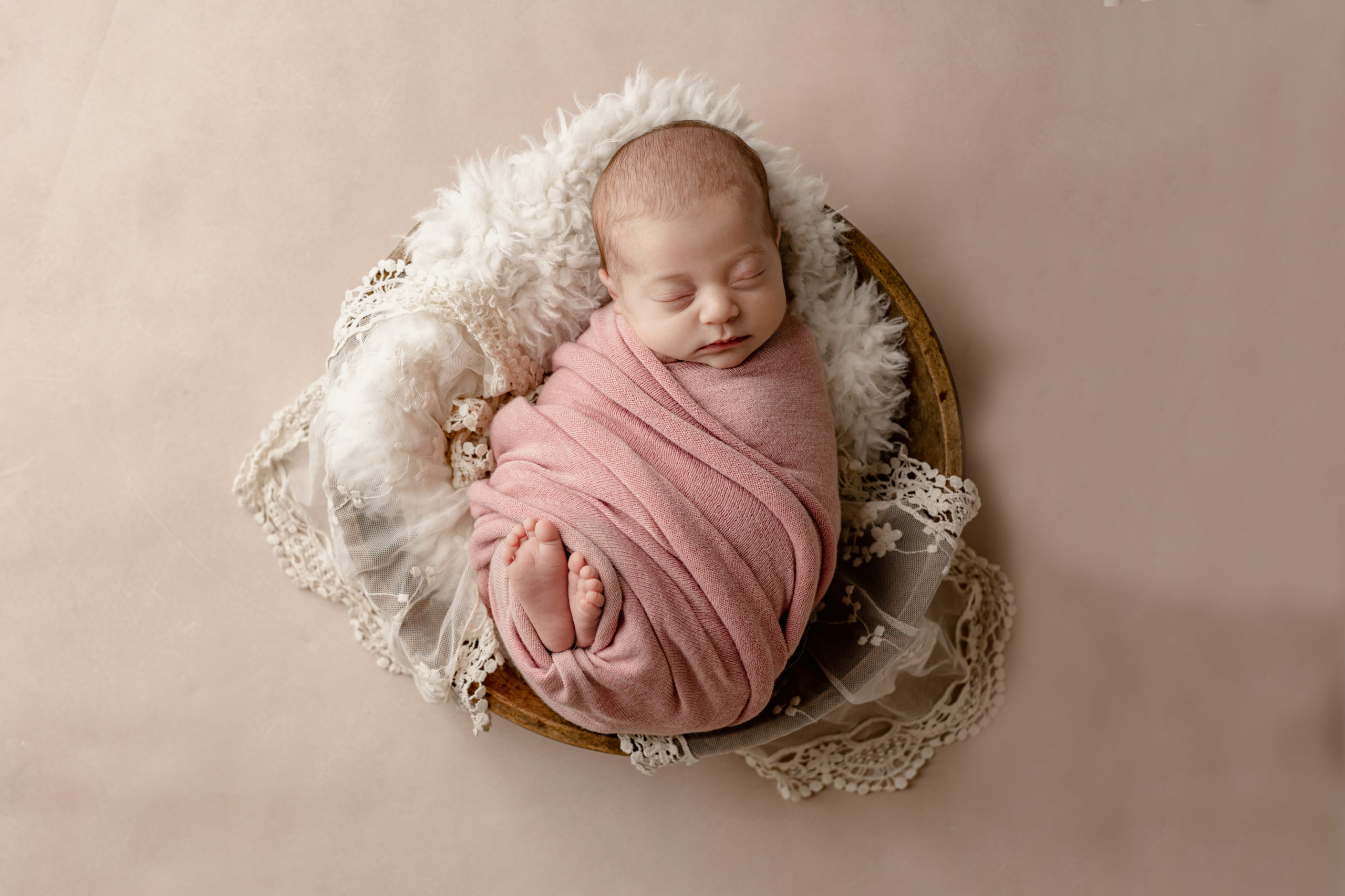 newborn baby girl wrapped in pink sleeping