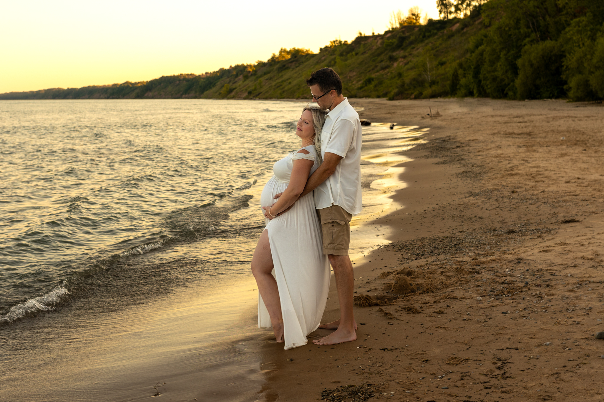 mom and dad to be holding each other by the water Pelvic Floor Therapy Milwaukee