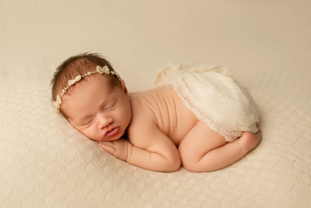 Newborn baby being soothed by a sound maching, laying on their stomach